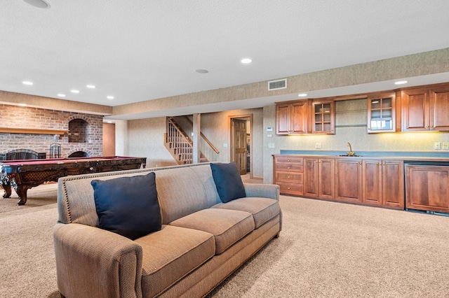 living area featuring a brick fireplace, recessed lighting, visible vents, and light carpet