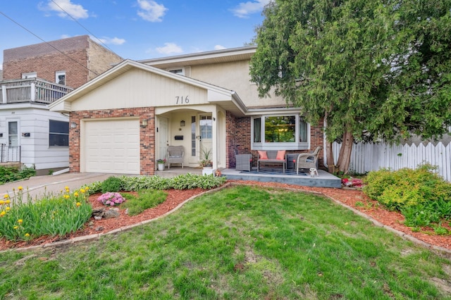 716 6th St NE, Minneapolis, MN 55413 - view of front of house with an attached garage, brick siding, concrete driveway, an outdoor hangout area, and stucco siding