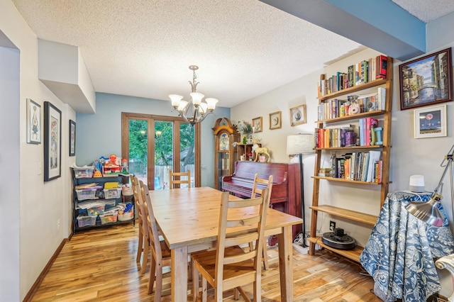716 6th St NE, Minneapolis, MN 55413 - dining space featuring a chandelier, light wood finished floors, a textured ceiling, and baseboards