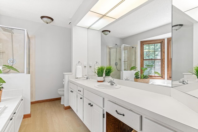 12534 Dover Dr, Apple Valley, MN 55124 - bathroom with double vanity, a shower stall, wood finished floors, and a bath