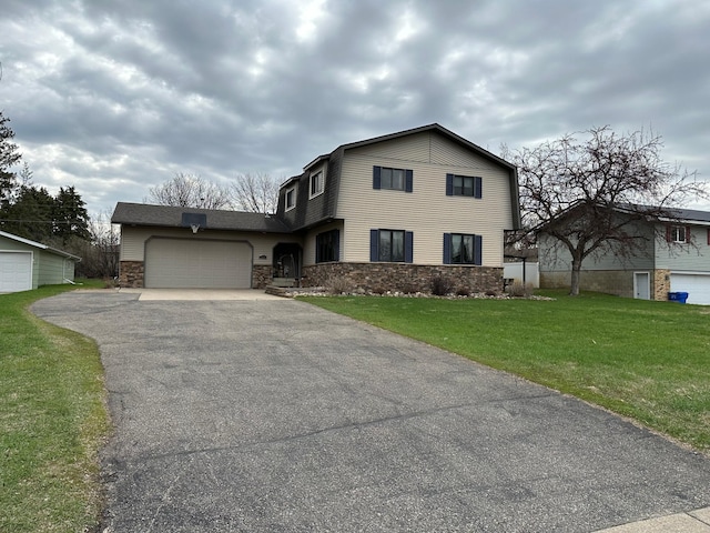 traditional home with a front yard, driveway, stone siding, and a garage