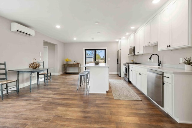 2737 Golfview Dr SW, Pine River Twp, MN 56474 - kitchen with appliances with stainless steel finishes, a wall mounted air conditioner, a center island, recessed lighting, and white cabinets
