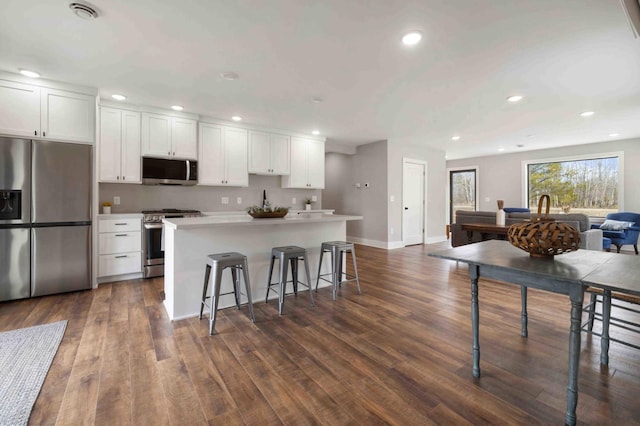 2737 Golfview Dr SW, Pine River Twp, MN 56474 - kitchen featuring appliances with stainless steel finishes, white cabinetry, a kitchen island, a kitchen breakfast bar, and recessed lighting
