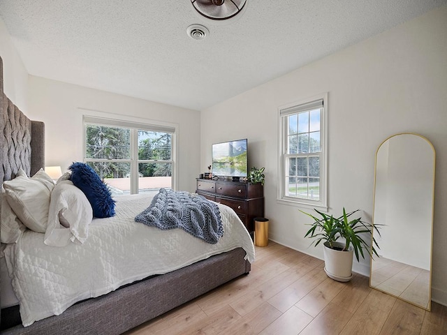 1883 County Road C E, Maplewood, MN 55109 - bedroom with multiple windows, wood finished floors, and a textured ceiling