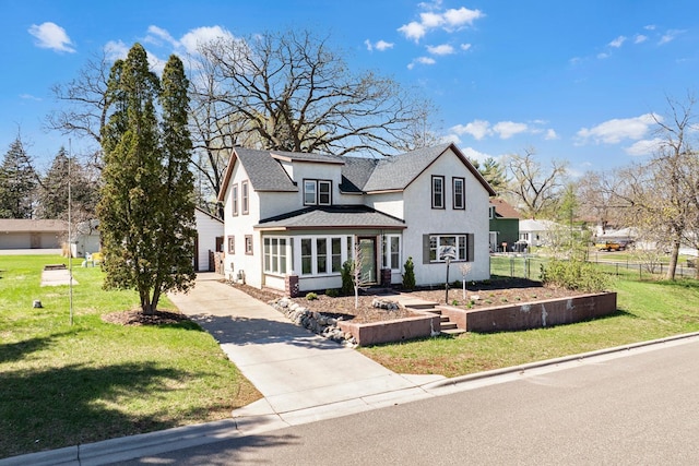 view of front of home with driveway, stucco siding, roof with shingles, and a front lawn