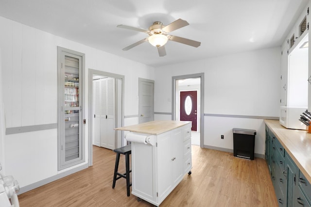 kitchen with a ceiling fan, light countertops, and light wood-style flooring