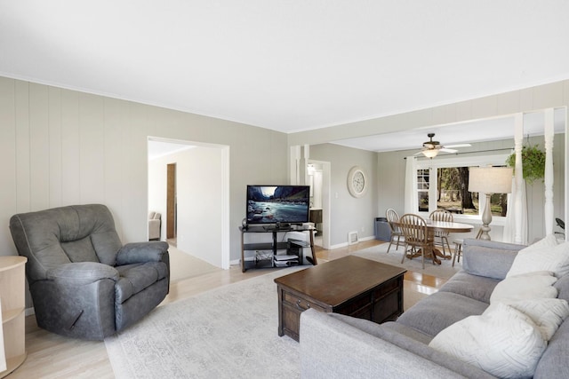living room with ceiling fan and light wood-type flooring
