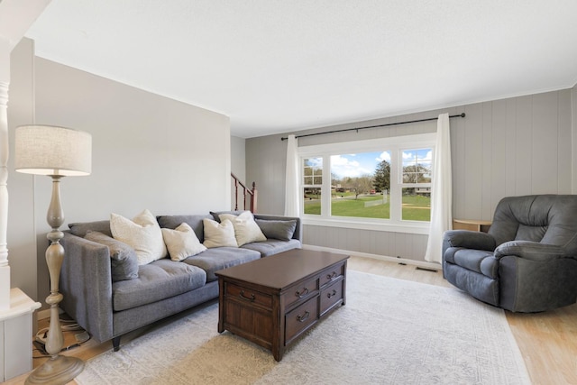living area featuring light wood finished floors, stairs, and visible vents