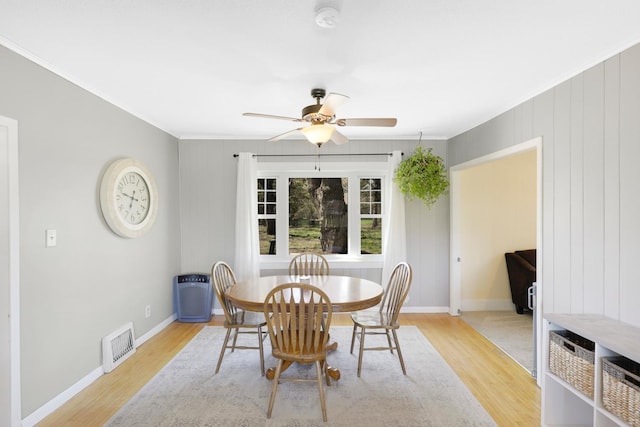 dining area with ornamental molding, a ceiling fan, visible vents, and light wood-style floors