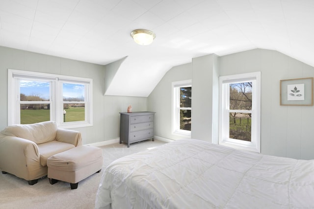 bedroom with vaulted ceiling, light carpet, and multiple windows