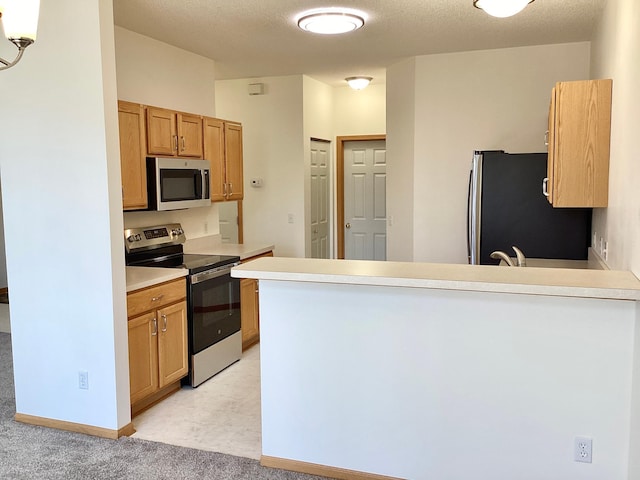 16873 79th Ave N, Maple Grove, MN 55311 - kitchen with appliances with stainless steel finishes, a peninsula, light countertops, light carpet, and a textured ceiling