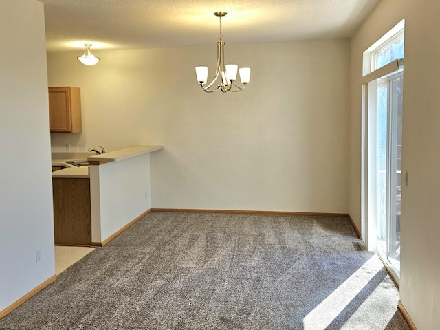 16873 79th Ave N, Maple Grove, MN 55311 - unfurnished dining area with light carpet, a chandelier, a sink, baseboards, and a textured ceiling