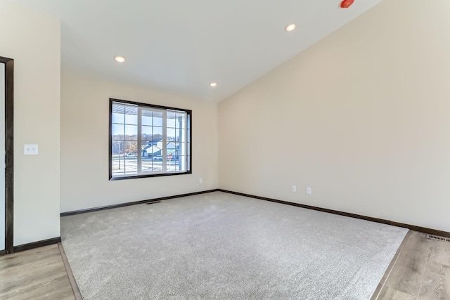 unfurnished room with recessed lighting, visible vents, baseboards, and lofted ceiling