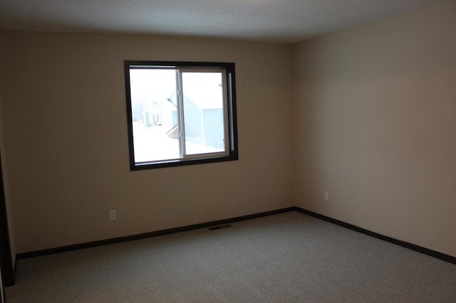carpeted empty room with baseboards and visible vents