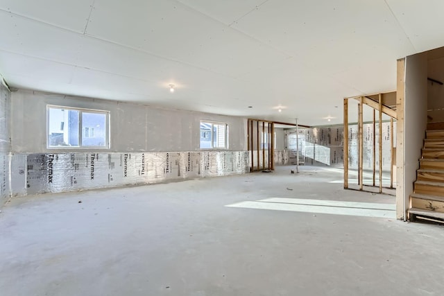 basement featuring a wealth of natural light and stairs