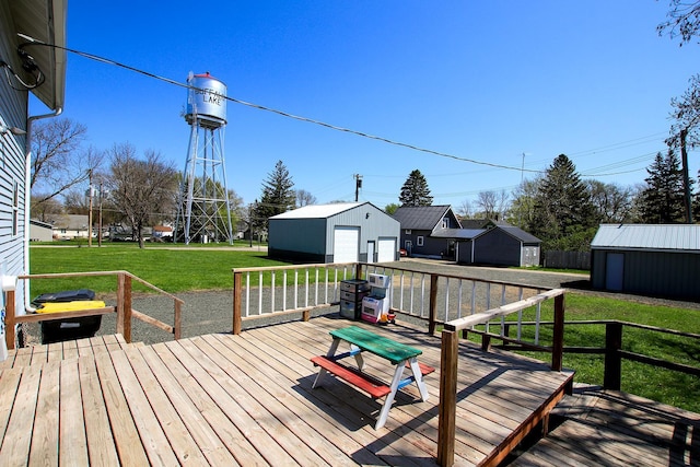 wooden terrace with a lawn, an outbuilding, and a detached garage