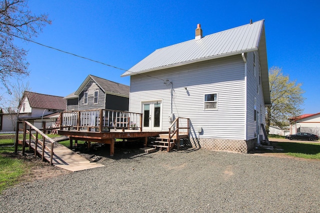 back of house with metal roof, a wooden deck, french doors, and a chimney