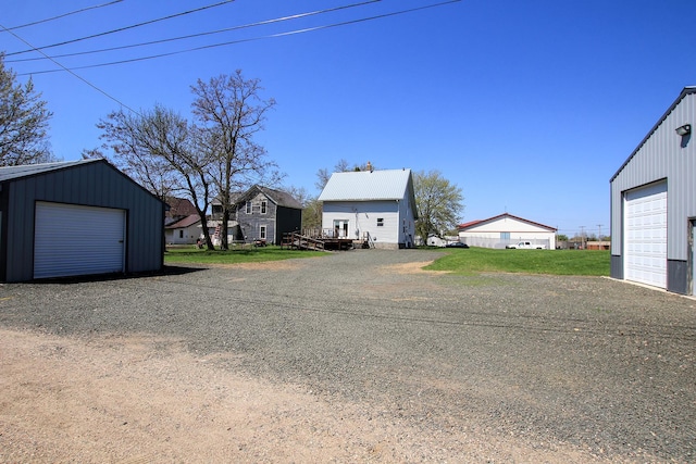exterior space with board and batten siding, a garage, an outbuilding, and a residential view