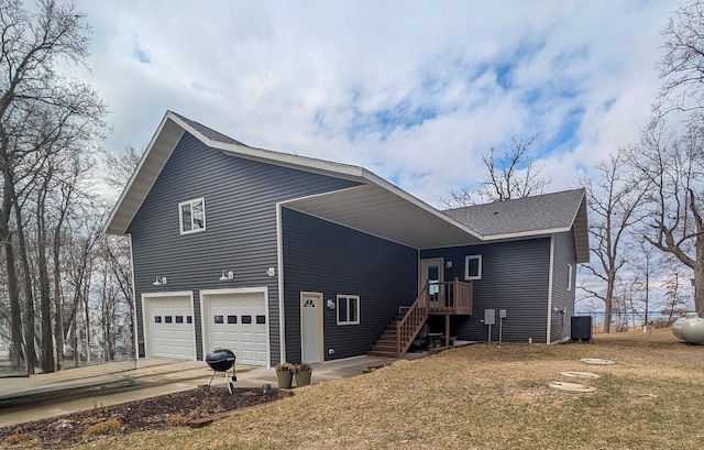 36861 477th Ave, Otto Twp, MN 56567 - rear view of property featuring central air condition unit, an attached garage, concrete driveway, a lawn, and a shingled roof