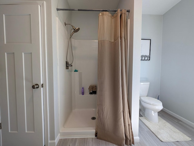 36861 477th Ave, Otto Twp, MN 56567 - bathroom featuring toilet, wood finished floors, a shower with curtain, and baseboards