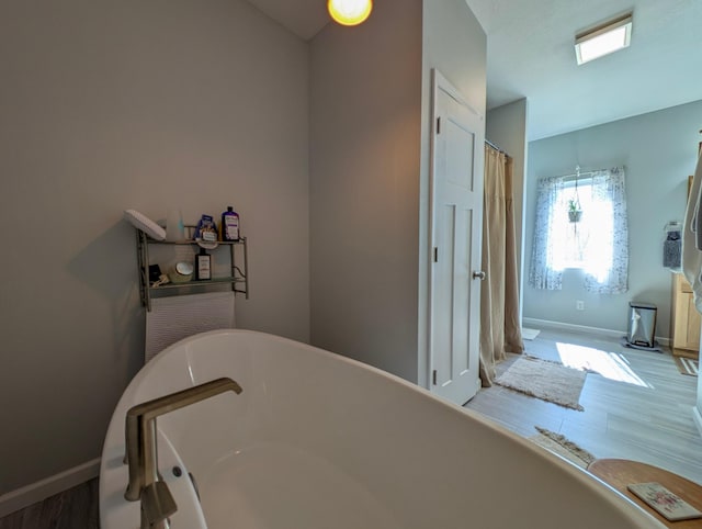 36861 477th Ave, Otto Twp, MN 56567 - full bath with a freestanding bath, baseboards, and wood finished floors