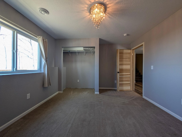 36861 477th Ave, Otto Twp, MN 56567 - unfurnished bedroom featuring a chandelier, a textured ceiling, carpet floors, a closet, and baseboards