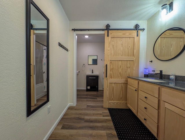 36861 477th Ave, Otto Twp, MN 56567 - bathroom featuring wood finished floors, vanity, a textured wall, baseboards, and curtained shower