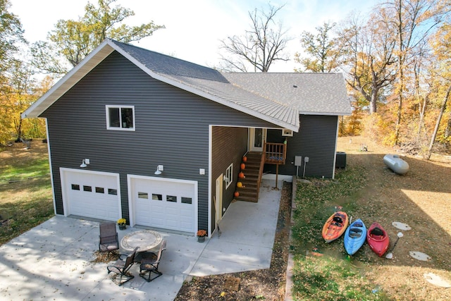 36861 477th Ave, Otto Twp, MN 56567 - view of side of property featuring concrete driveway, a shingled roof, an attached garage, and cooling unit