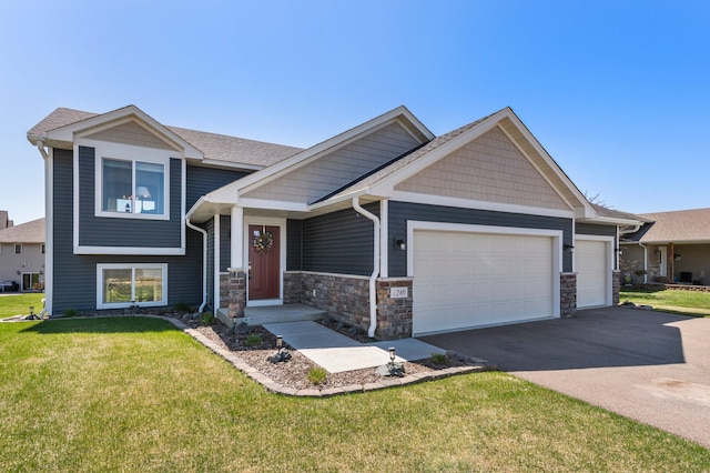 view of front of home with a garage, a front lawn, driveway, and stone siding