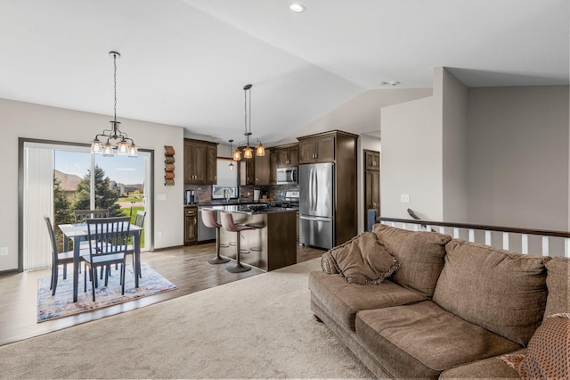 living area featuring recessed lighting, dark wood finished floors, a chandelier, and vaulted ceiling