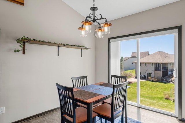 dining space featuring baseboards, wood finished floors, and a chandelier