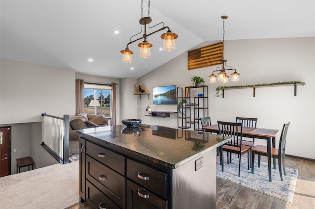 kitchen with dark wood-style flooring, vaulted ceiling, dark stone countertops, a chandelier, and recessed lighting