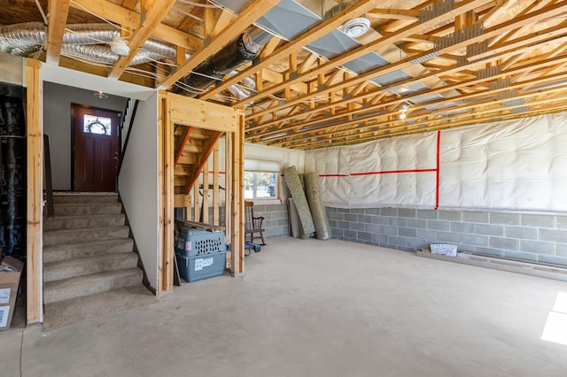 below grade area featuring concrete block wall and stairway