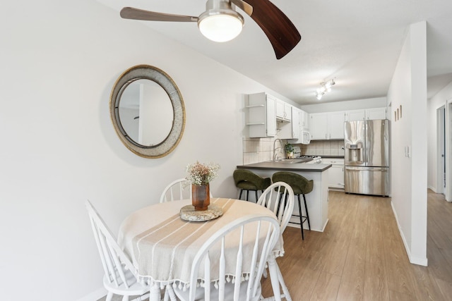 dining area featuring light wood-style flooring and a ceiling fan