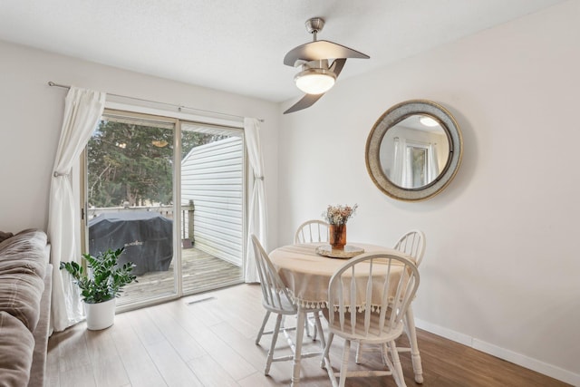 dining space featuring baseboards, wood finished floors, and visible vents