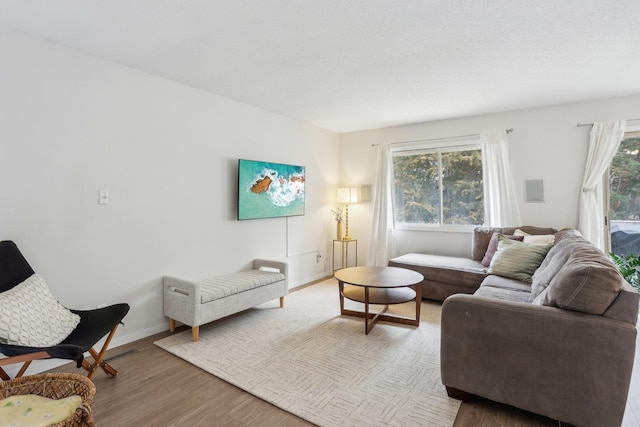 living area with baseboards and light wood finished floors