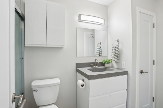 full bath with toilet, vanity, and a shower