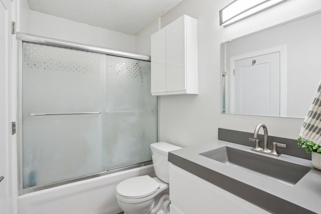 full bath featuring vanity, bath / shower combo with glass door, and toilet