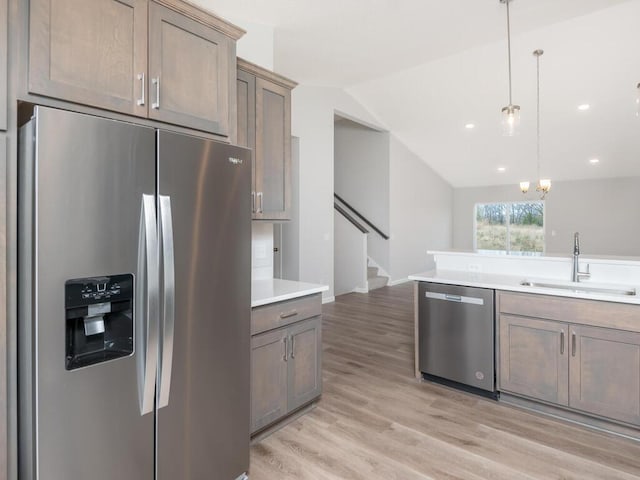 539 Winkler Trl N, Cologne, MN 55322 - kitchen with appliances with stainless steel finishes, light wood-style flooring, light countertops, lofted ceiling, and a sink