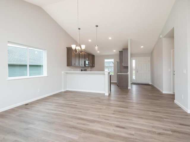 539 Winkler Trl N, Cologne, MN 55322 - unfurnished living room with light wood-style flooring, recessed lighting, an inviting chandelier, and baseboards