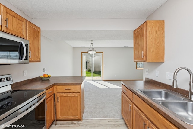 128 Oakmont Ln, Red Wing, MN 55066 - kitchen with appliances with stainless steel finishes, a sink, dark countertops, a peninsula, and light wood-type flooring
