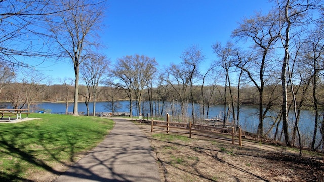 view of property's community with a lawn and a water view