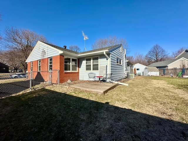 back of property with an outdoor structure, a storage unit, fence, a yard, and brick siding
