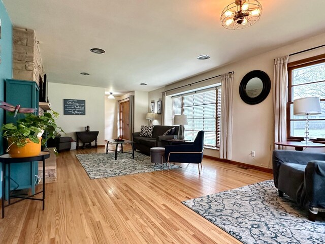 living room featuring a healthy amount of sunlight, light wood finished floors, and baseboards