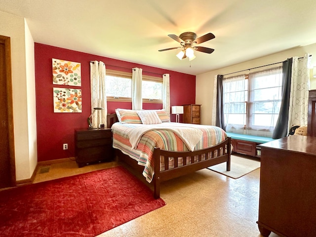 bedroom featuring a ceiling fan, multiple windows, and light floors