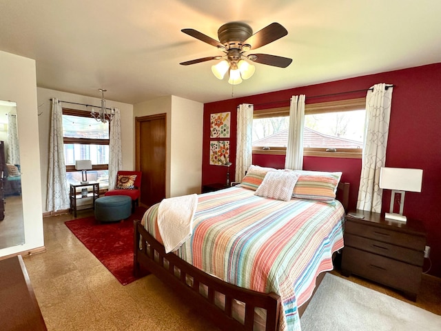 bedroom with ceiling fan, baseboards, and multiple windows
