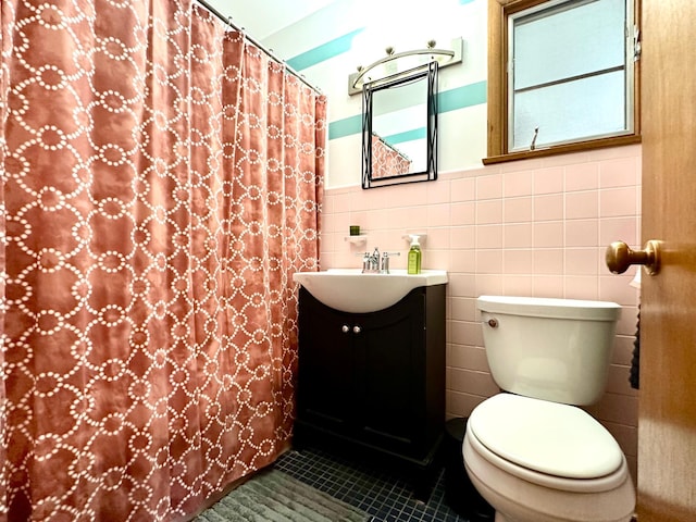 full bath featuring tile patterned floors, vanity, toilet, and tile walls