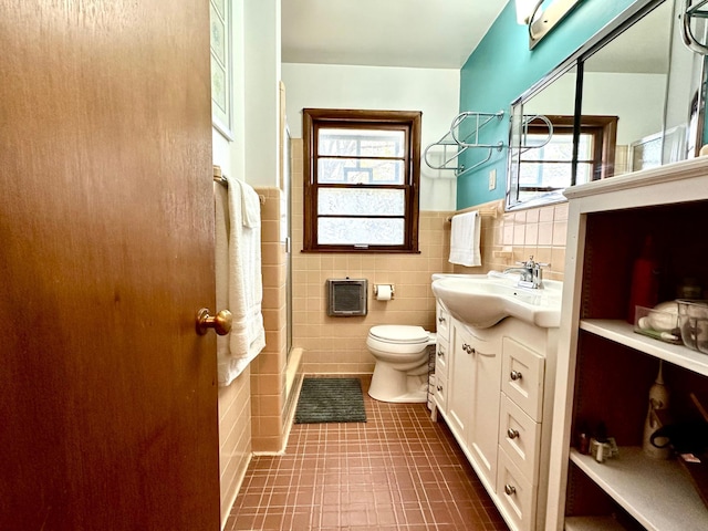 full bathroom with an enclosed shower, heating unit, toilet, tile walls, and vanity