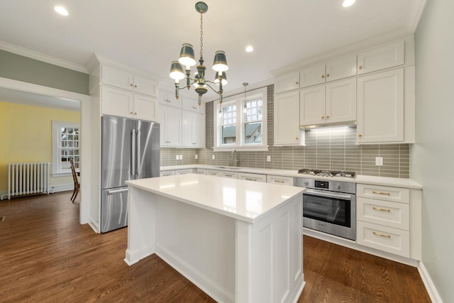 525 Main St, Owatonna, MN 55060 - kitchen with crown molding, radiator, an inviting chandelier, appliances with stainless steel finishes, and light countertops