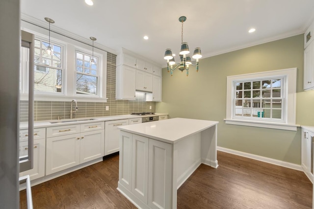525 Main St, Owatonna, MN 55060 - kitchen featuring white cabinetry, light countertops, backsplash, dark wood-type flooring, and a sink